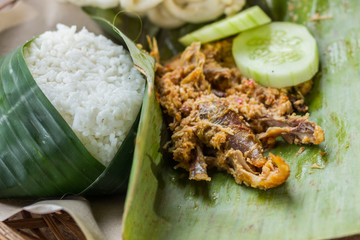 Grilled chicken with coconut chili sauce, rice and vegetables, a typical food from Banyuwangi, Indonesia