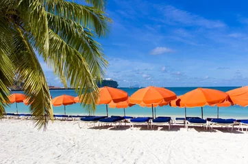 Papier Peint photo Caraïbes  beach chairs and  red umbrellas on caribbean island St. Maarten