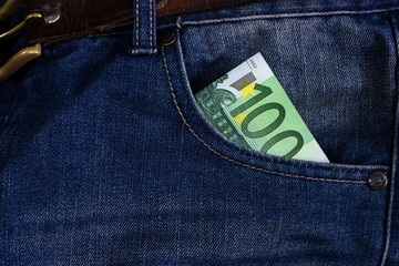euro bills sticking out of the front pocket of jeans