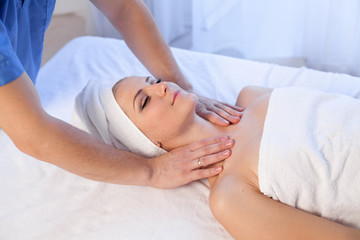 a massage therapist makes therapeutic massage of the face and neck in the Spa medicine