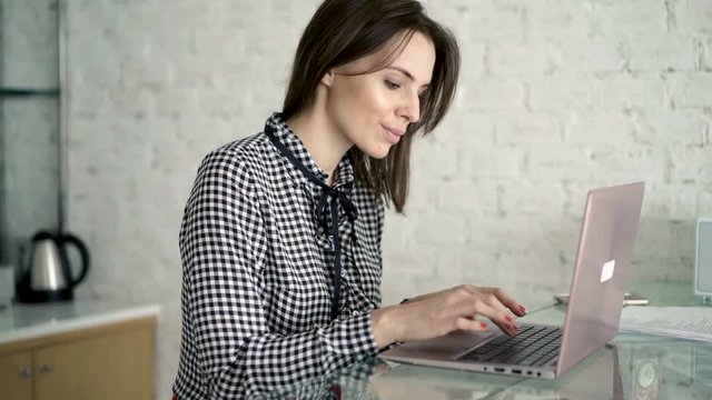 Pretty, young businesswoman working with laptop at home, 4K
