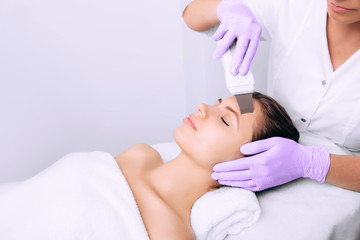 Obraz na płótnie Canvas Beautiful woman receiving ultrasound cavitation facial peeling. Cosmetology and facial skin care