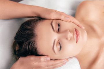 Obraz na płótnie Canvas woman enjoying a relaxing head massage at spa salon