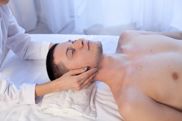 Fototapeta na wymiar a massage therapist makes therapeutic massage of the face and neck in the Spa medicine