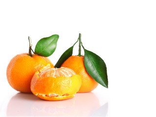 three tasty mandarin isolated. citrus tangerine or clementine with green leaves and one without peel