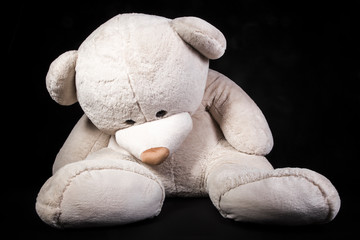 white big bear toy with orange eyes on a black background