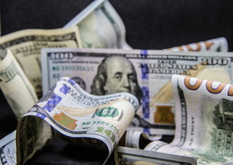 a lot of hundred dollar bills on a black background