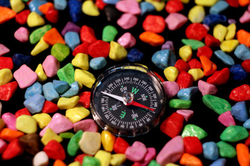 compass on colorful pebbles