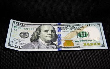 one hundred dollars on a black background