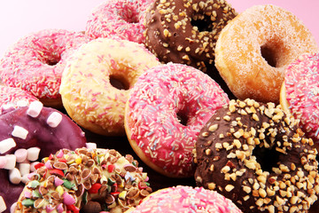 assorted donuts with chocolate frosted, pink glazed and sprinkles donuts