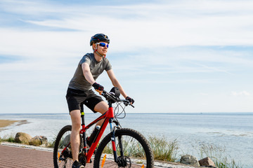 Fototapeta na wymiar Young man biking at seaside