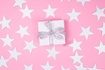 White gift box on pink background.