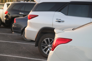 Closeup of rear side of white car parking in parking lot.