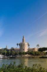Golden Tower in Seville with the Guadalquivir river and a beautiful blue sky at sunset (Torre del Oro, Sevilla) Andalusia, Spain