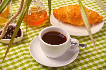 Fresh croissant with cup of coffee on the table.