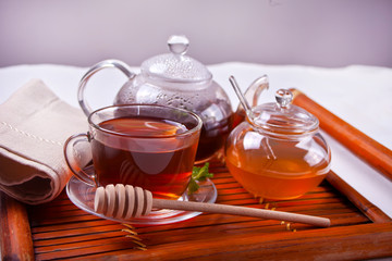 Cup of mint tea on a wooden background.