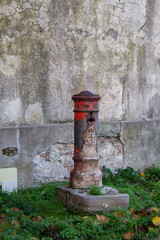 Fototapeta na wymiar старый пожарный гидрант на фоне серой стены