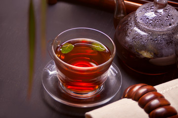 Cup of mint tea on a wooden background.