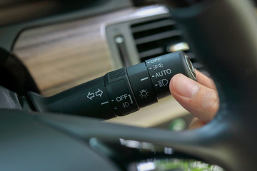 driver hand using switch arm stick control light sign turn left or left and open mode of headlight...