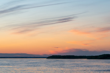 Beautiful sunset on the river. Summer sunset or sunrise landscape with golden light in Yakutia, Republic of Sakha, Russia. Riverscape taken from a ferry on river Lena