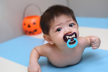 little kid baby sucking nipple pacifier teeth vampire dracula devil, costume of halloween celebration party