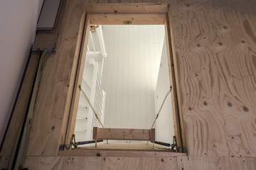 Wooden staircase to the attic in a modern house empty