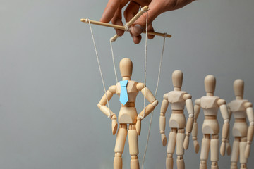Leader puppet activist and workers. Concept of how to manage leader in team. Doll in tie on the...