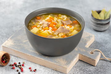 Rassolnik - Traditional Russian soup with pickled cucmbers, pearl barley, meat, pickles, carrots and potatoes  on light background. Top view