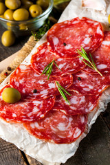 Chorizo sausage and salami, thin cut. spanish salami on the wood background with spices, paprika, pepper. Spicy food. Chili.