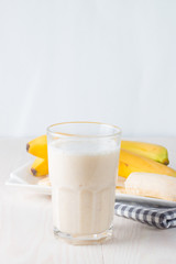Fresh Made Chocolate Banana Smoothie on a wooden table. Selective focus. Milkshake with almonds. Protein diet. Healthy food and drink concept.