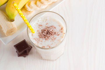 Fresh Made Chocolate Banana Smoothie on a wooden table. Selective focus. Milkshake with almonds. Protein diet. Healthy food and drink concept.
