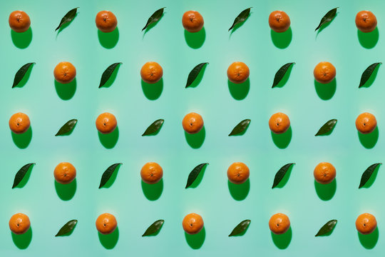 Tangerine pattern with leaves on a cold green color background with vertical shadows in high resolution