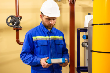 Industrial technician worker in helmet with tool for measurement