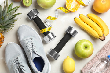 Flat lay composition with sport items and healthy food on grey background. Weight loss concept