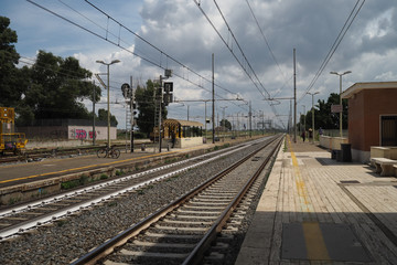 Naklejka premium Gorący dzień na stacji kolejowej Santa Severa, patrząc wzdłuż toru z czekającymi pasażerami