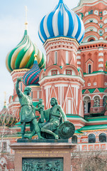 Fototapeta na wymiar Monument to Minin and Pozharsky with the words: “To Citizen Minin and Prince Pozharsky from grateful Russia”. In background some of the colored steeples ot Saint Basil's Cathedral in Moscow, Russia
