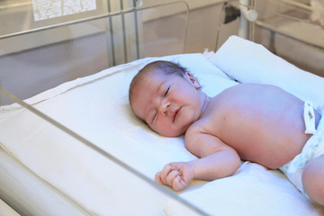 Newborn child under ultraviolet light in hospital