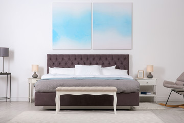 Stylish room interior with large comfortable bed