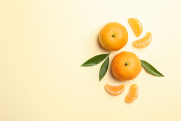 Composition with tangerines and leaves on color background, flat lay. Space for text