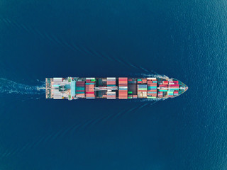 Aerial top view container ship on the sea full speed transport container for logistics import export or shipping background.