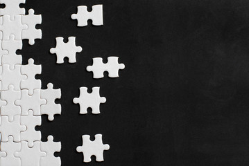 White details of puzzle on black background. With copy space