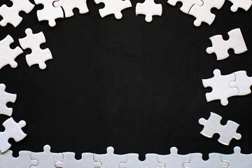 White details of puzzle on black background. With copy space