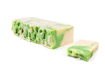 Handmade green and white artisan noni soap loaf and soap bar on white background