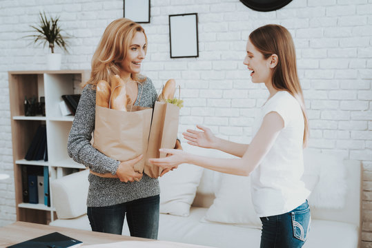 Mother with Packs of Food from Store at Home.