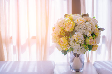 white and green color flower vase on sofa near window curtain light