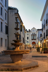 Fototapeta premium treviso di sera per la città e strada con fontana in italia, europa, evening in treviso city in the street with fountain in italy, europe
