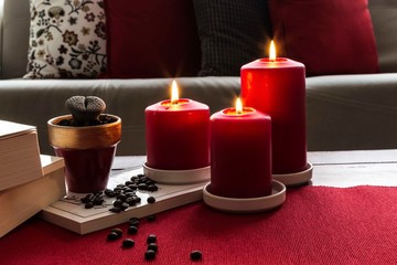 Christmas or new year decoration with red candle and coffee . Living room interior and holiday home decor concept.
