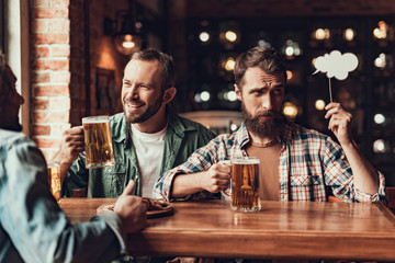 Cheerful friends with drinks spending time at pub