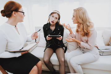 Girl Listens to Music in Psychologist Office.