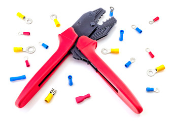 Crimping tool and electrical connectors isolated on white background closeup